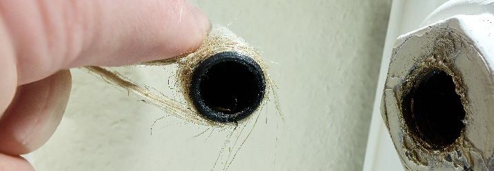 Hand hält Hanfseil an Heizungsrohr
